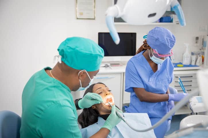 A general dentist and his assistant are helping their patient in Las Vegas