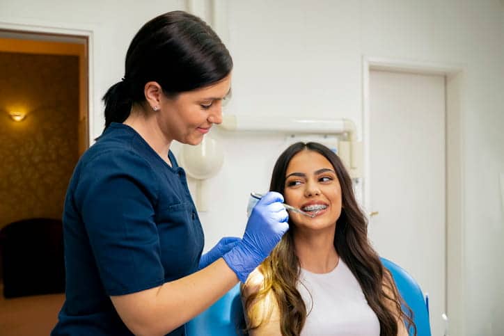 Las Vegas orthodontics; an orthodontist is helping her patient with metal braces.