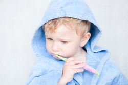 A toddler cleaning his teeth before a visit to the dentist