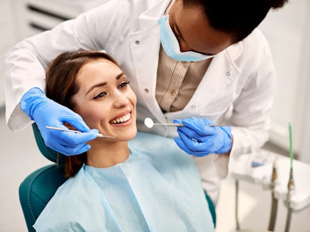 Female dentist helping dental patient