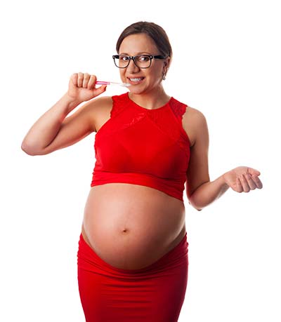 pregnant woman brushing teeth