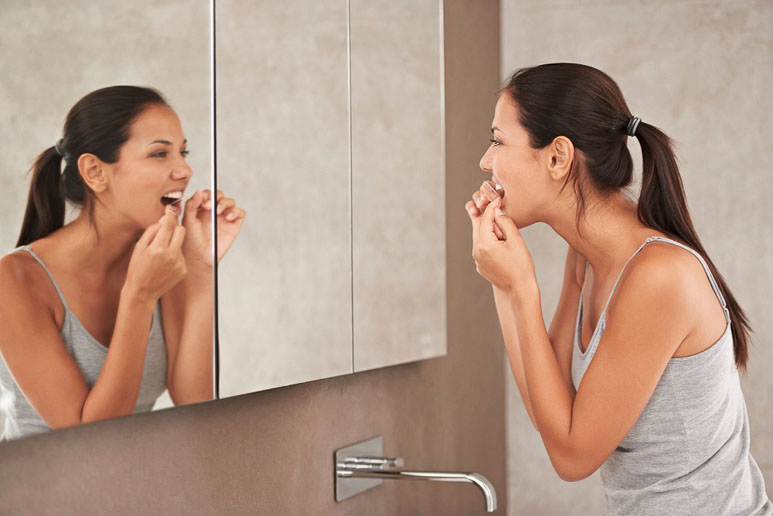 Woman flossing teeth