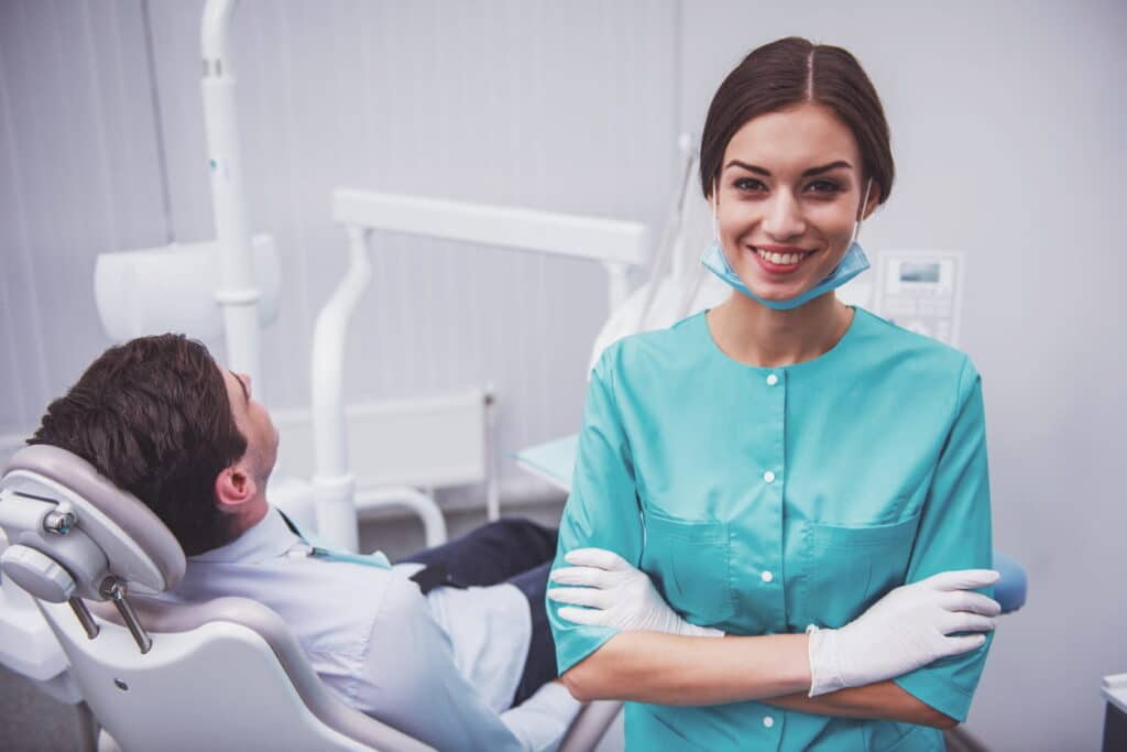 A Las Vegas dentist smiling as she sits next to her patient.