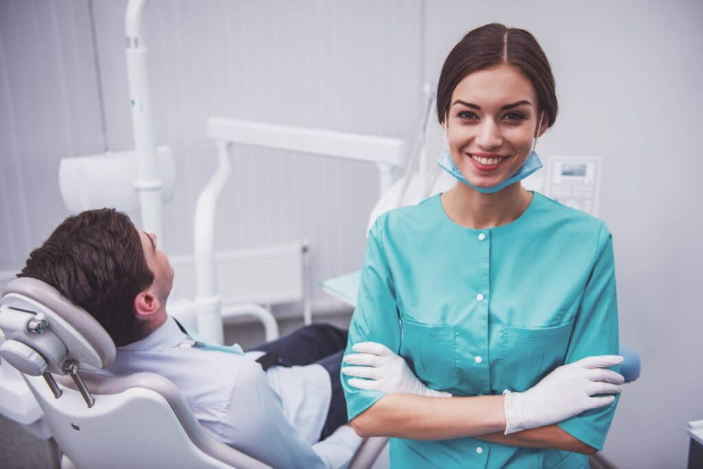 A las vegas dentist smiling as she sits next to her patient.