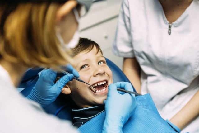 Pediatric dentist doing dental work on a child