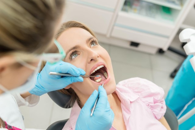 Blonde woman having dental exam done by dentist
