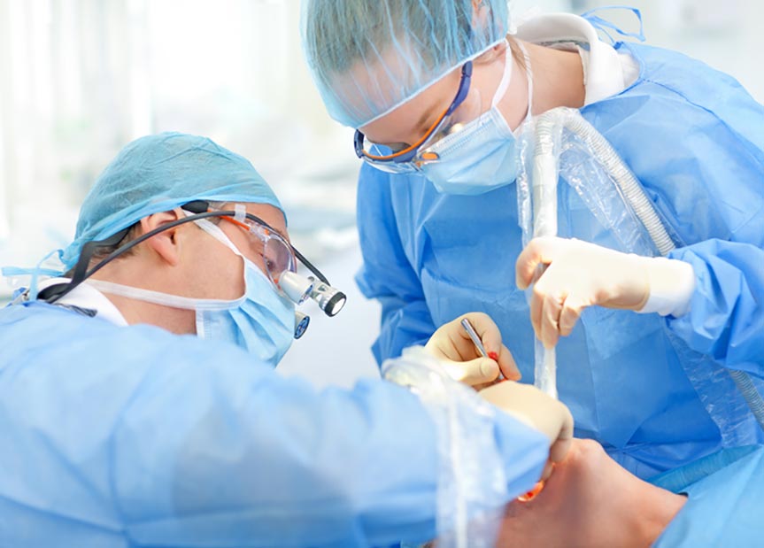 surgeons placing dental implants in patient