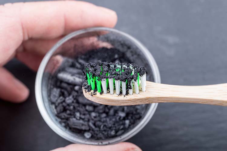 Charcoal on a toothbrush to whiten teeth