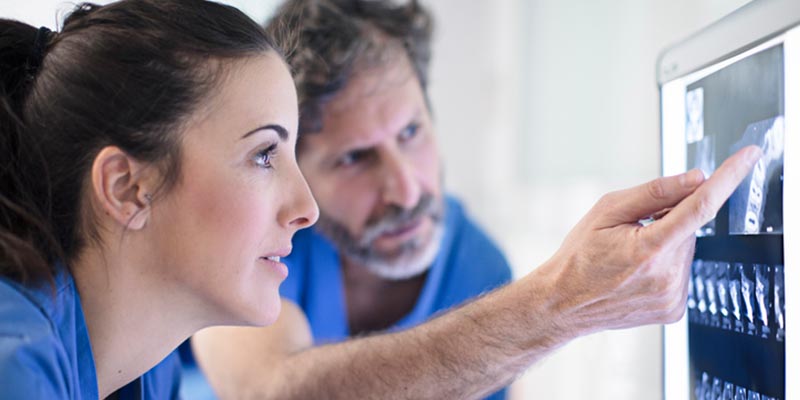 How Dental Implants Help With Bone Loss 2 Dentists looking at x-ray