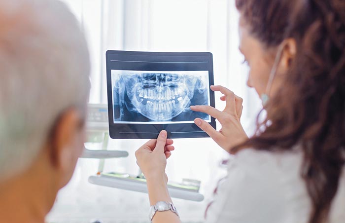 Dentist showing x-ray to patient