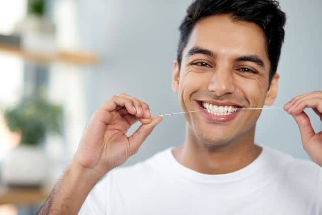 male flossing his teeth