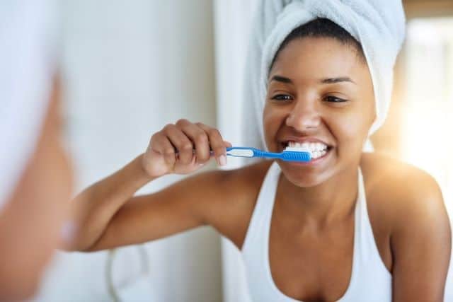 woman brushing her teeth correctly