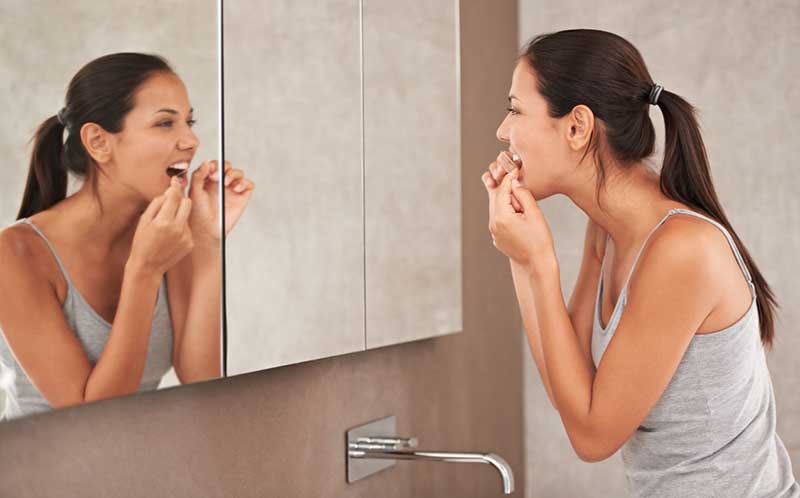 Woman flossing her teeth 