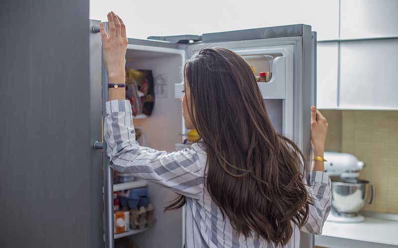 Woman looking into fridge 