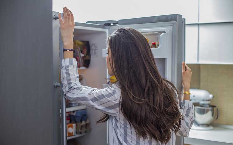 Woman looking into fridge