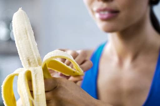 Woman with braces eating a banana