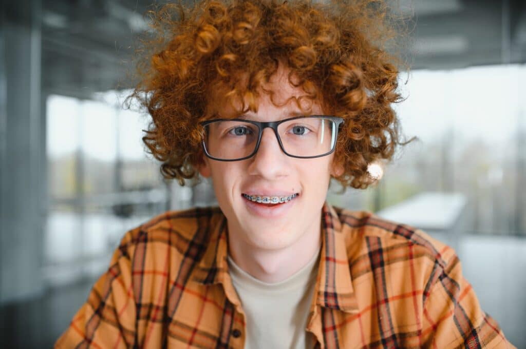 A teenager smiling with braces.