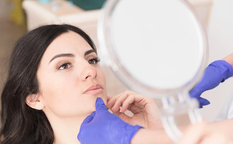Woman looking in mirror after botox treatment