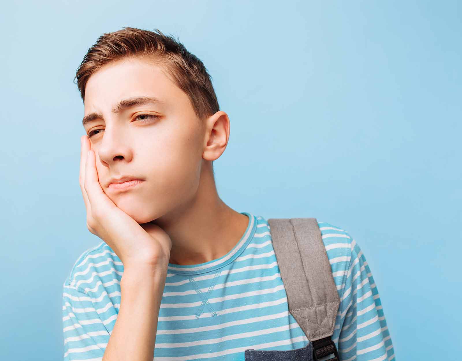 young male with puffy cheeks after getting his wisdom teeth extracted