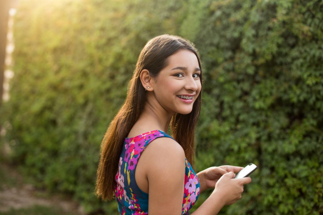 A girl with metal braces using her mobile phone