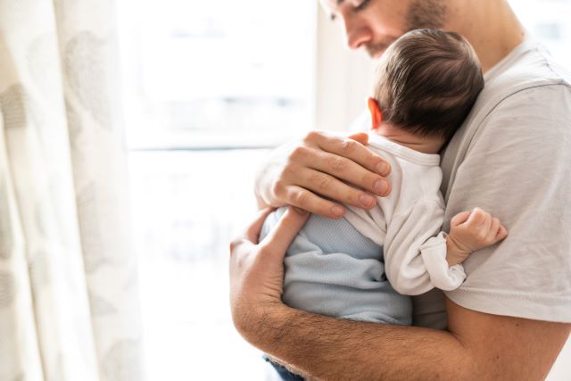 father soothing his teething baby