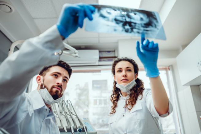 Healthcare, medical and radiology concept - two dentist doctors looking at x-ray. selective focus.