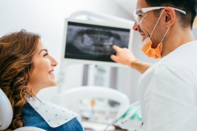 Dentist and patient looking at a digital dental x-ray.