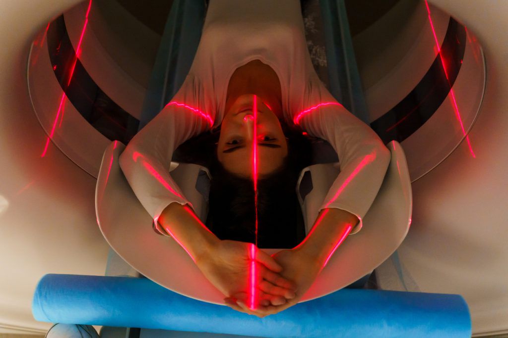 Red rays scan a girl on computed tomography ct scan of the abdomen for a woman to cure appendicitis, tumors, cysts, abdominal aortic aneurysm, blood clots of the abdominal