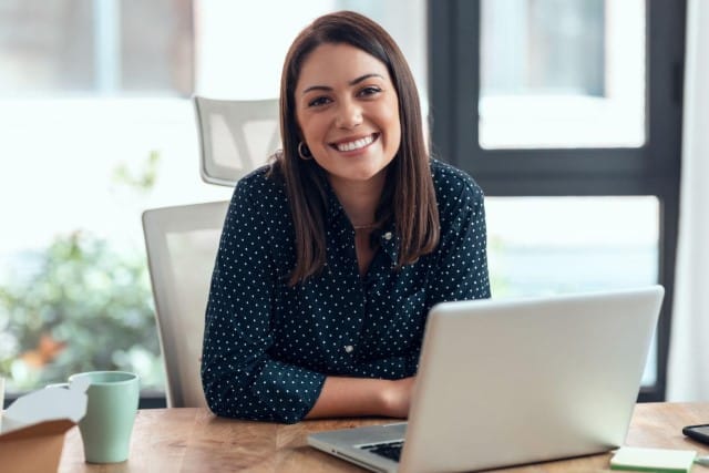 Woman Smiling at Desk