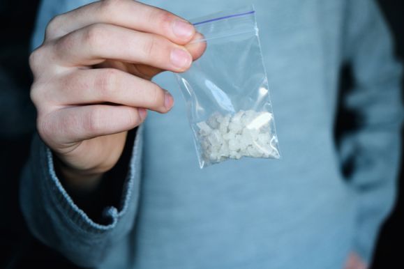 hand holds packet with methamphetamine