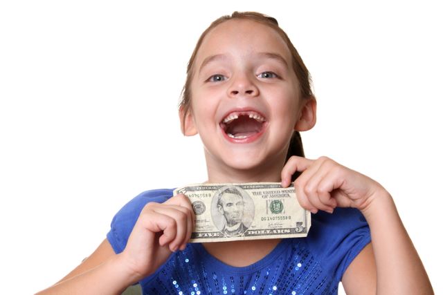 Child holding up money from the tooth fairy