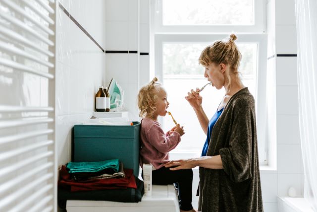 Mom and daughter brushing teeth together