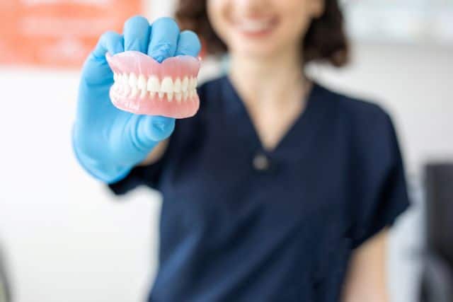 Dentist holding dentures