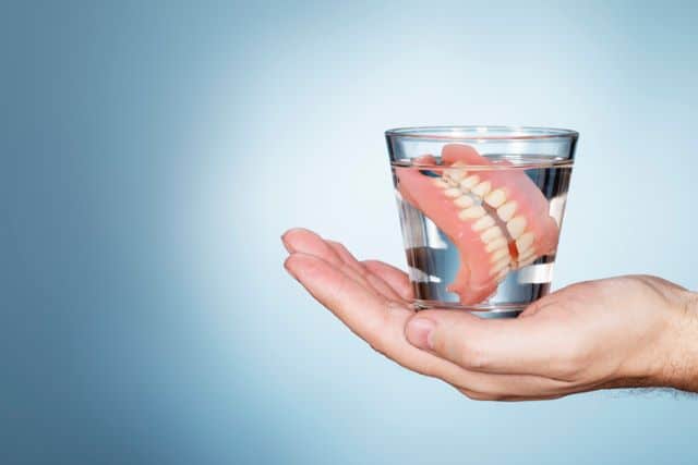 Dentures soaking in cleaning solution