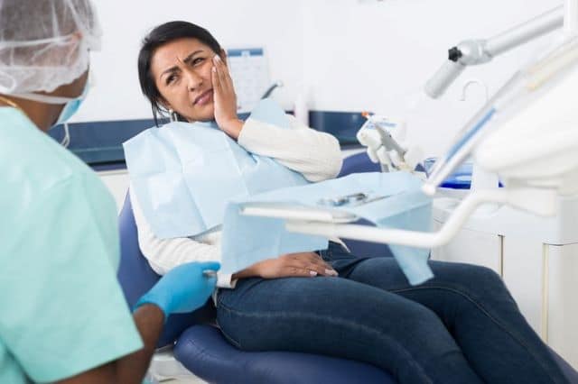 Woman seeing a dentist for a excruciating toothache