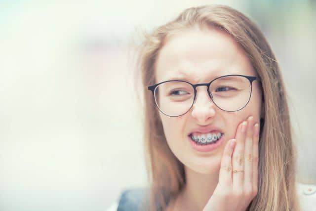Young girl experiencing pain due to a braces issue