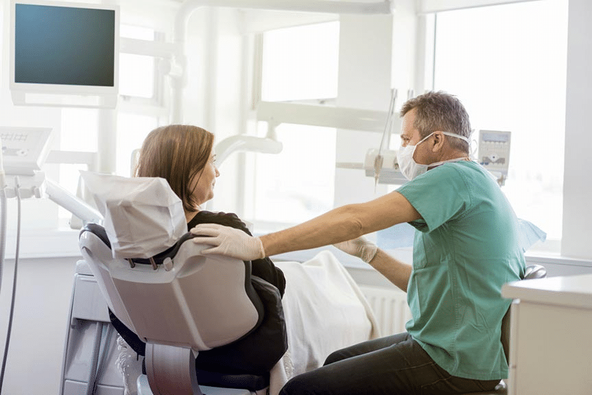 Image of male dentist discussion dental procedure with female patient.