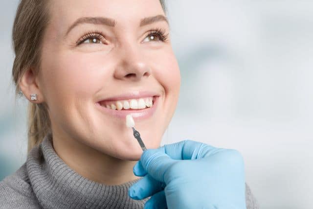 dentist trying to match the veneer color to her teeth