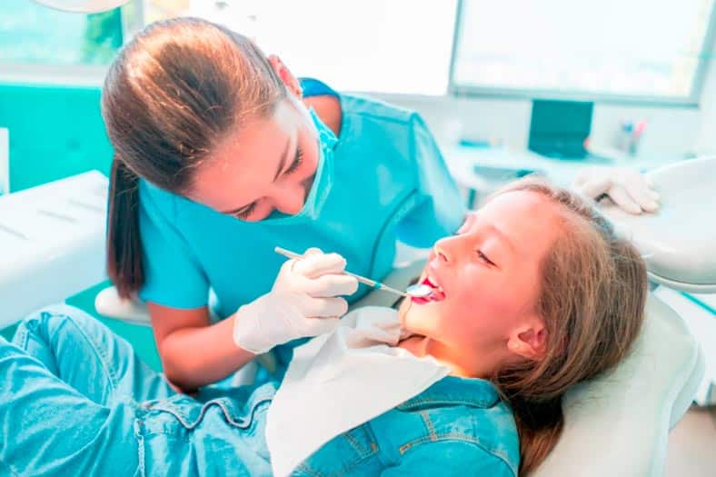 dentist checking kid's teeth for cavities