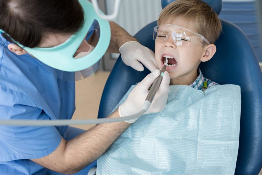 pediatric dentist cleaning child's teeth