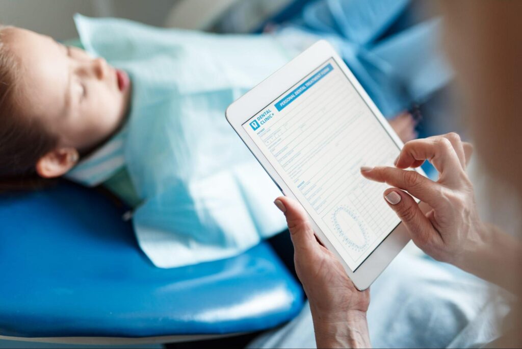 Dentist looking over tablet paper work for child