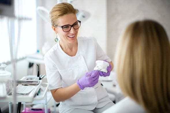 Dentist showing a model dental implant
