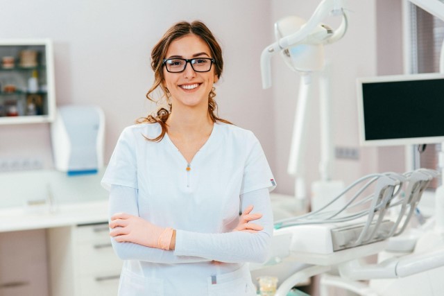 Orthodontist standing with arms crossed and glasses on