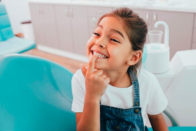 Smiling Child Pointing to Teeth