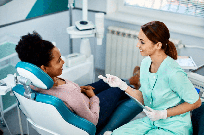 a female dentist giving her female patient care instructions for after wisdom tooth removal.