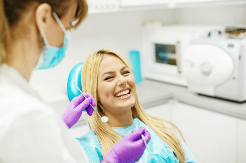 a female dentist giving her female patient care instructions for after wisdom tooth removal.