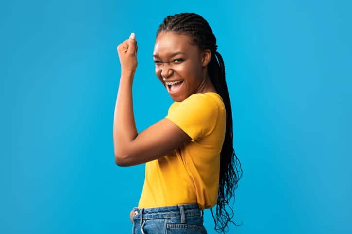 A teenager smiling and cheering for her metal braces.