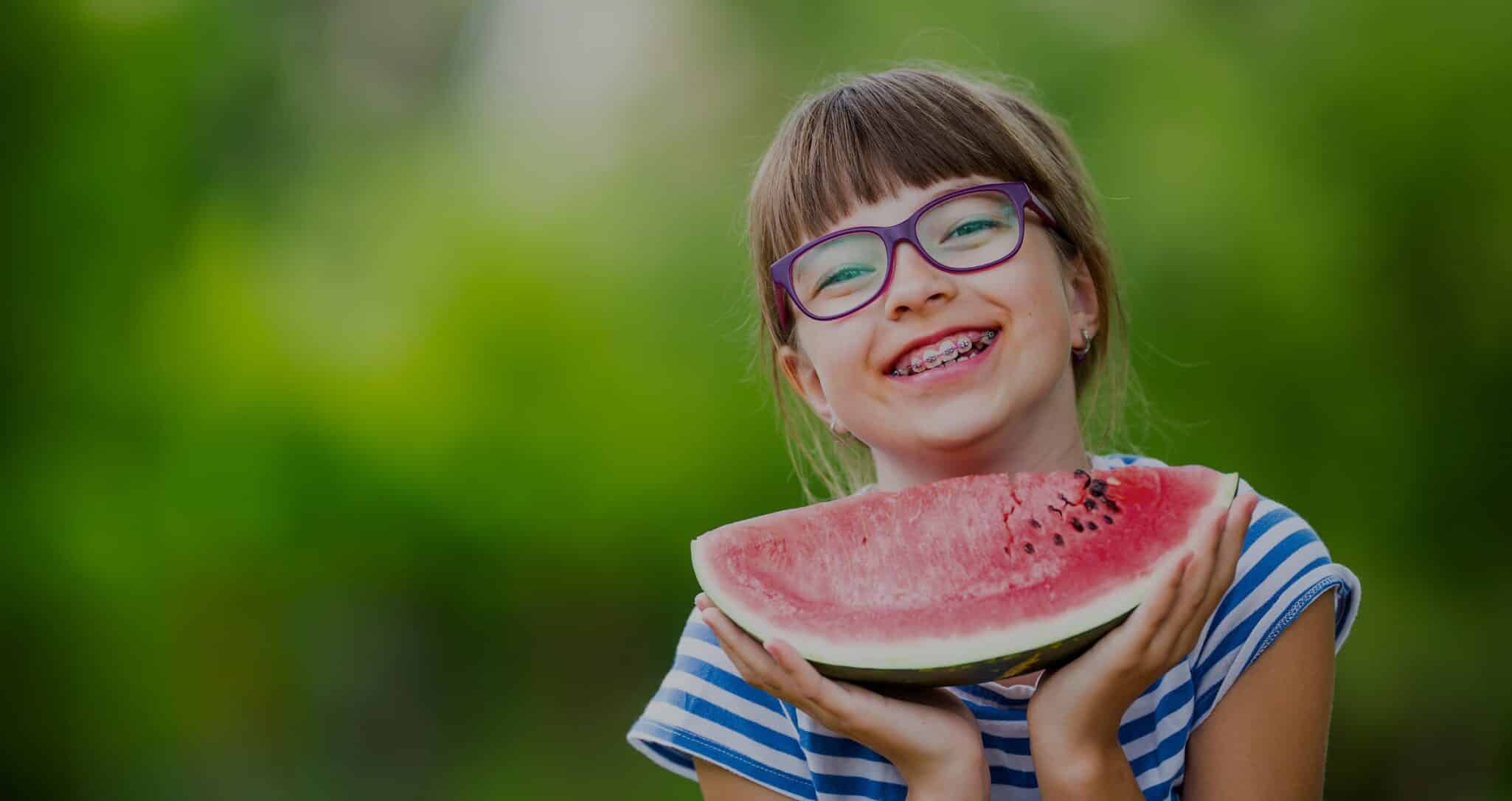 child with braces and watermelon