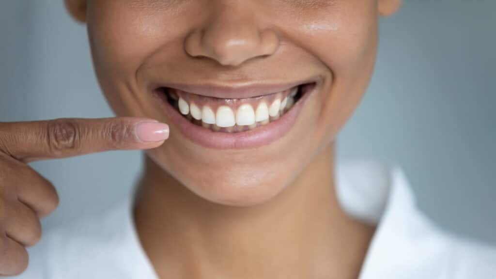 A closeup of a UNR graduate student's smile as she points to it.