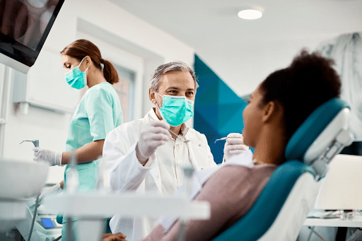 A dentist and his assistant examining a patient.